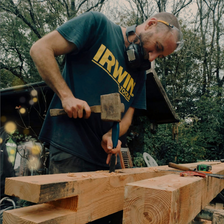 Nick from bluestone landscaping working on a piece of wood with a mallet