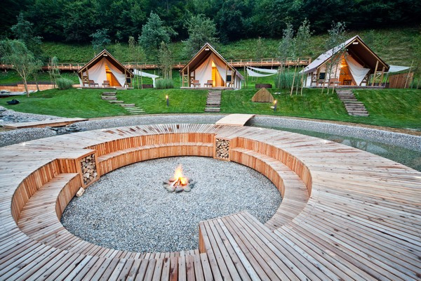 a circular seating area around a firepit in front of tents