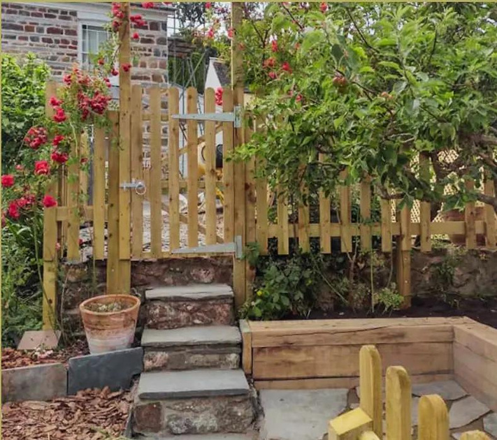 a garden with steps and a fence