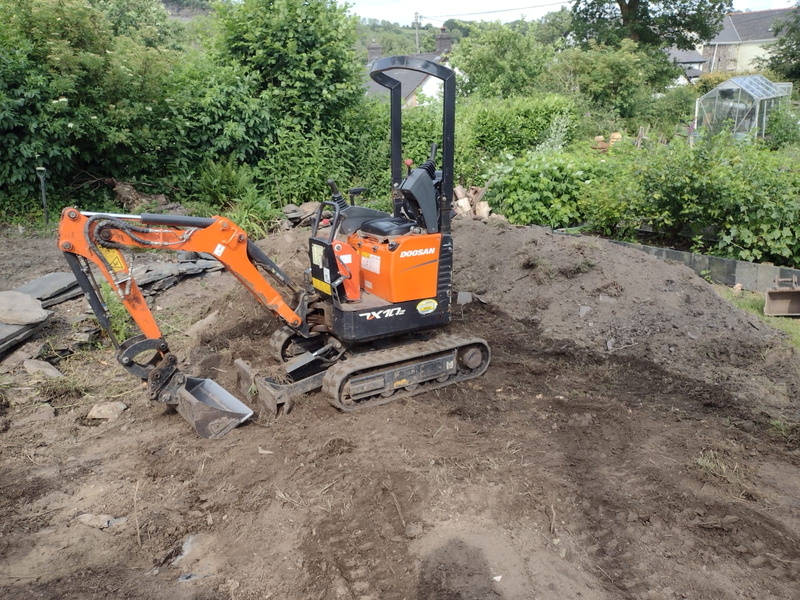 a small excavator sitting on top of a pile of dirt