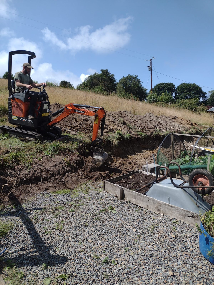 a person in a digger digging a hole in the ground