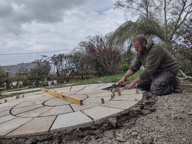 Nick from Bluestone landscaping laying a circular patio